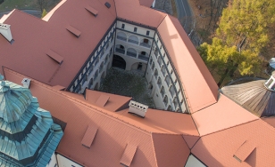 Zdjęcie przedstawia Zamek w Pieskowej Skale z lotu ptaka. Na pierwszym planie czerwone, spadziste dachy zamku.